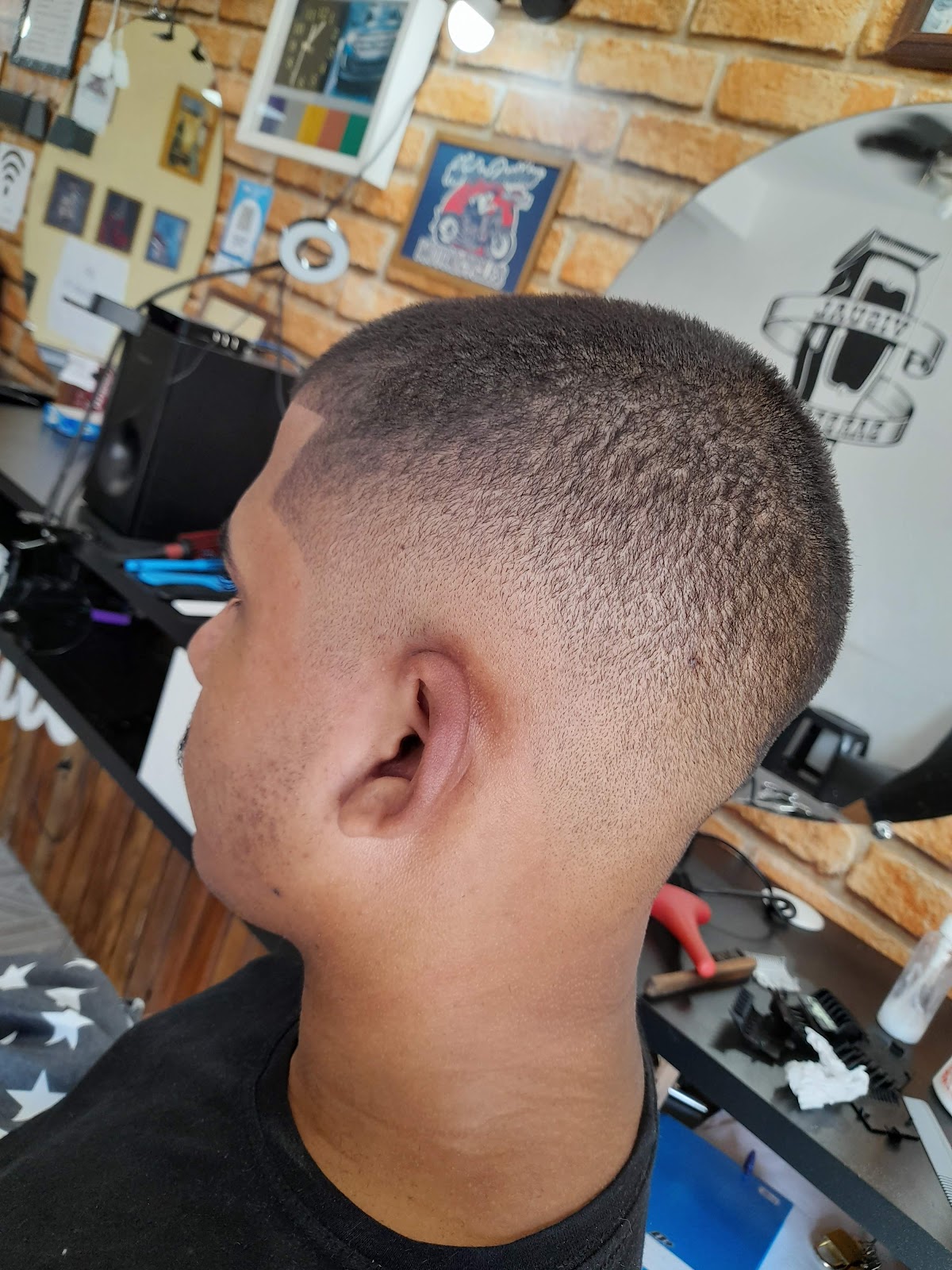 Acabamento do corte degradê visto de perfil, com parede de tijolo aparente ao fundo